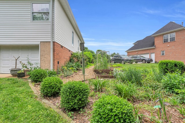 1028 Ivy Manor Ct, Hixson, TN 37343 - view of side of home with a garden, brick siding, and an attached garage