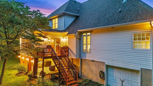 1028 Ivy Manor Ct, Hixson, TN 37343 - back of property at dusk featuring a shingled roof, a garage, stairs, and a wooden deck