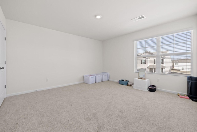 spare room with carpet floors, baseboards, and visible vents