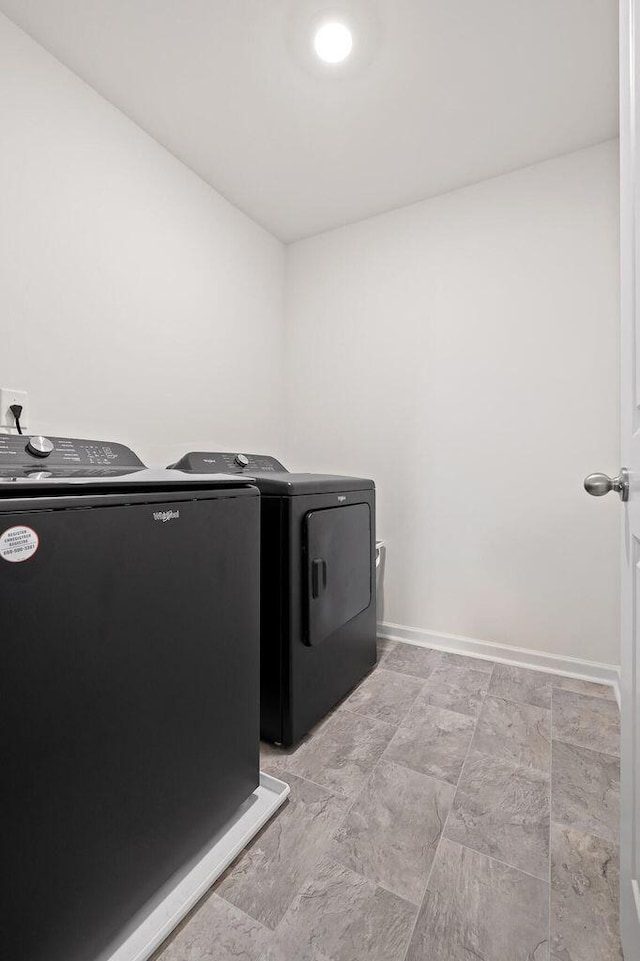 washroom with laundry area, baseboards, and washing machine and clothes dryer