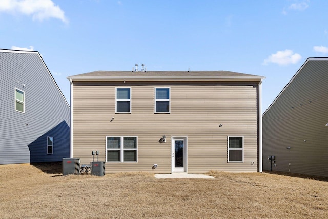 back of property with a lawn and central air condition unit