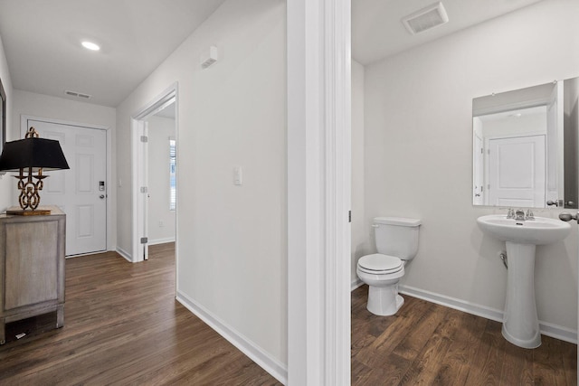 bathroom featuring toilet, baseboards, and wood finished floors