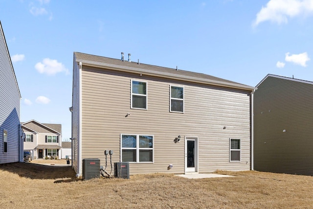 back of house featuring a lawn and cooling unit