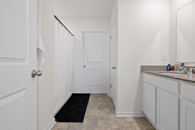 full bathroom with vanity and baseboards