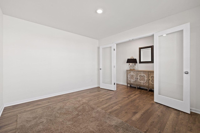 unfurnished room with recessed lighting, wood finished floors, and baseboards