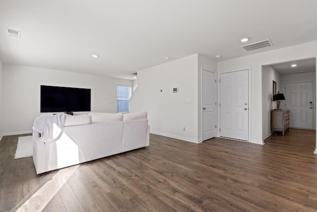 living room with baseboards, visible vents, and dark wood-style flooring