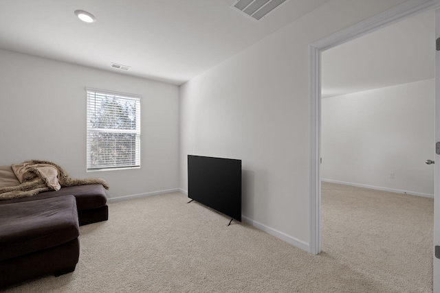 living area with light colored carpet, visible vents, and baseboards