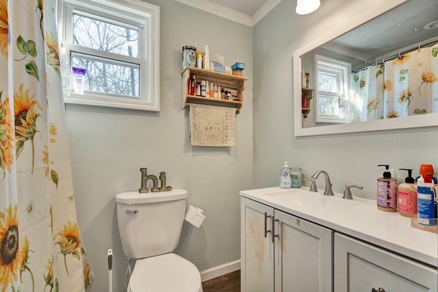 bathroom featuring plenty of natural light, vanity, ornamental molding, and toilet