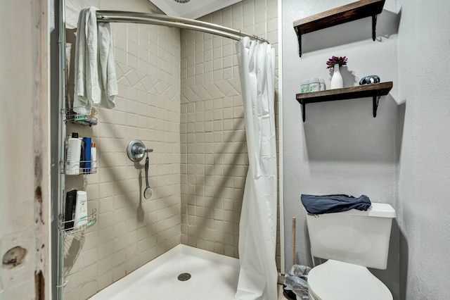 bathroom with a shower with curtain and toilet