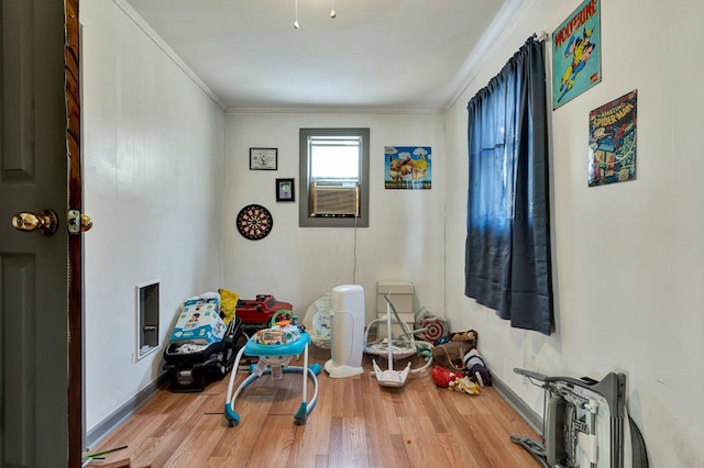 game room with light wood-type flooring and ornamental molding