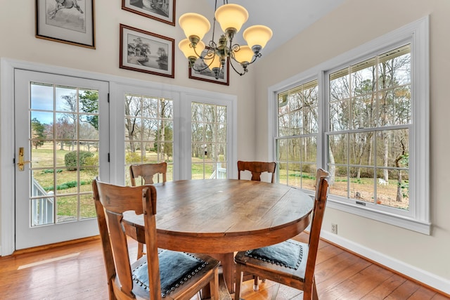 dining area featuring a chandelier, plenty of natural light, and light wood finished floors