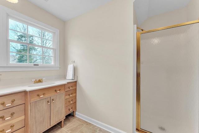 bathroom with tile patterned floors, baseboards, a stall shower, and vanity