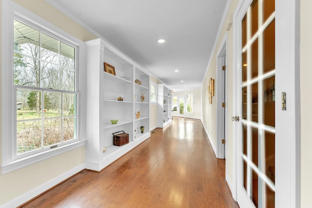 hallway featuring crown molding, recessed lighting, wood finished floors, and baseboards