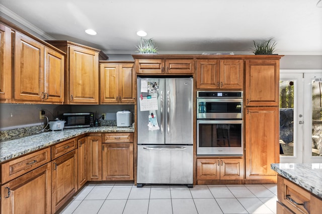 kitchen with stainless steel appliances, ornamental molding, light stone countertops, brown cabinetry, and light tile patterned floors