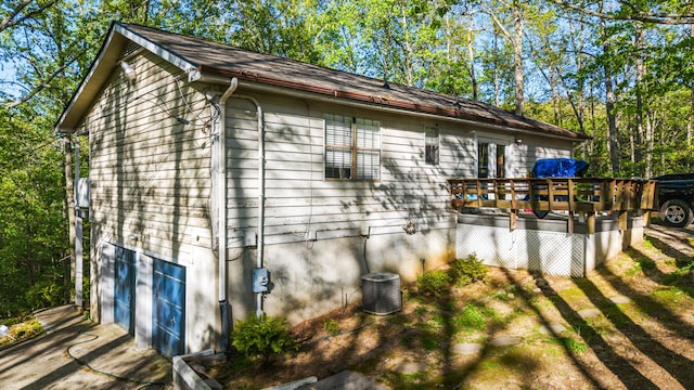 view of side of home with a wooden deck and central AC
