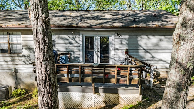 rear view of house featuring central AC, a wooden deck, a shingled roof, and french doors