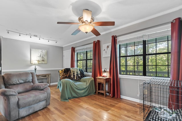 living room with track lighting, wood finished floors, a ceiling fan, and crown molding