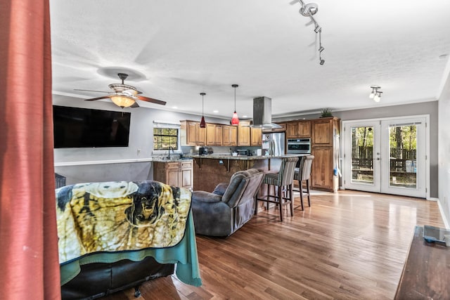 interior space with ceiling fan, french doors, wood finished floors, and a textured ceiling
