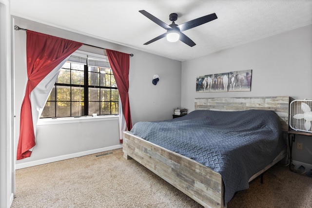 bedroom with visible vents, baseboards, carpet floors, and ceiling fan