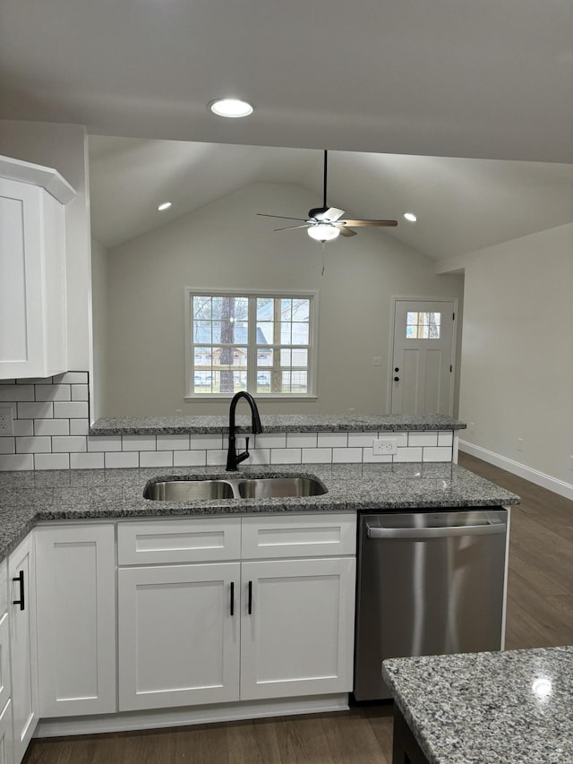 kitchen featuring white cabinets, dishwasher, lofted ceiling, and sink