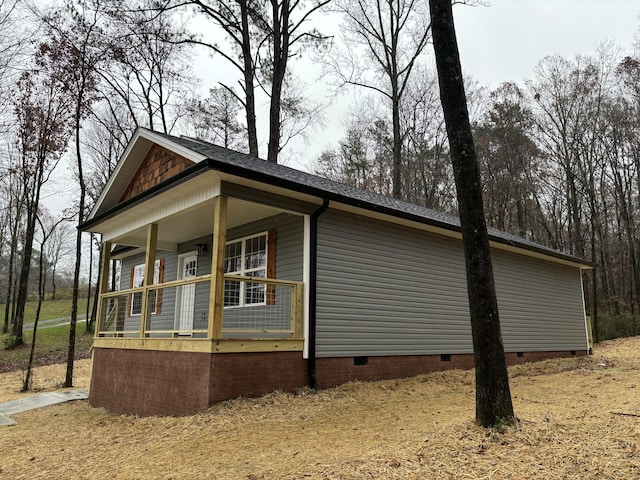 view of side of home featuring covered porch