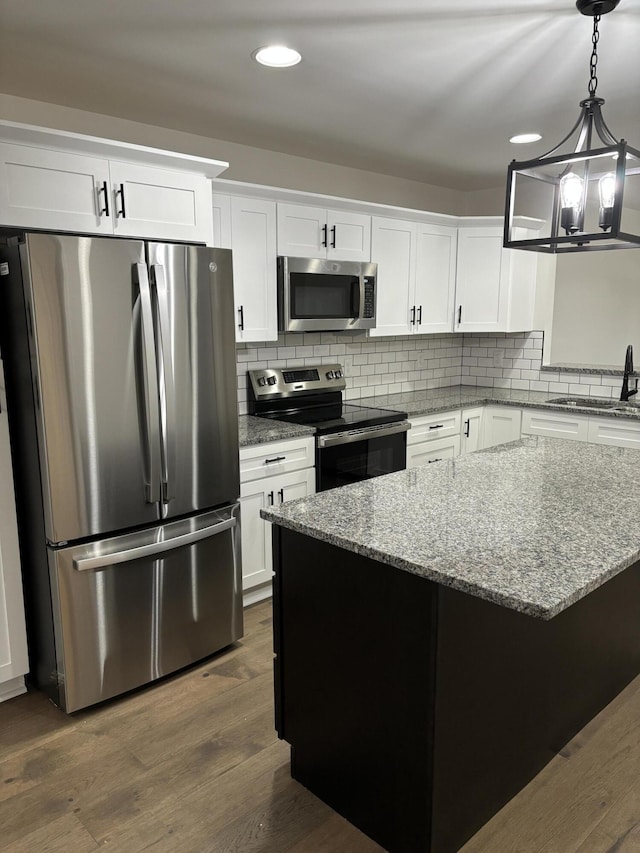 kitchen featuring white cabinets, sink, dark hardwood / wood-style floors, light stone countertops, and stainless steel appliances