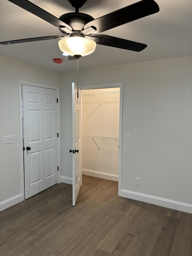 unfurnished bedroom with a closet, ceiling fan, and dark hardwood / wood-style flooring