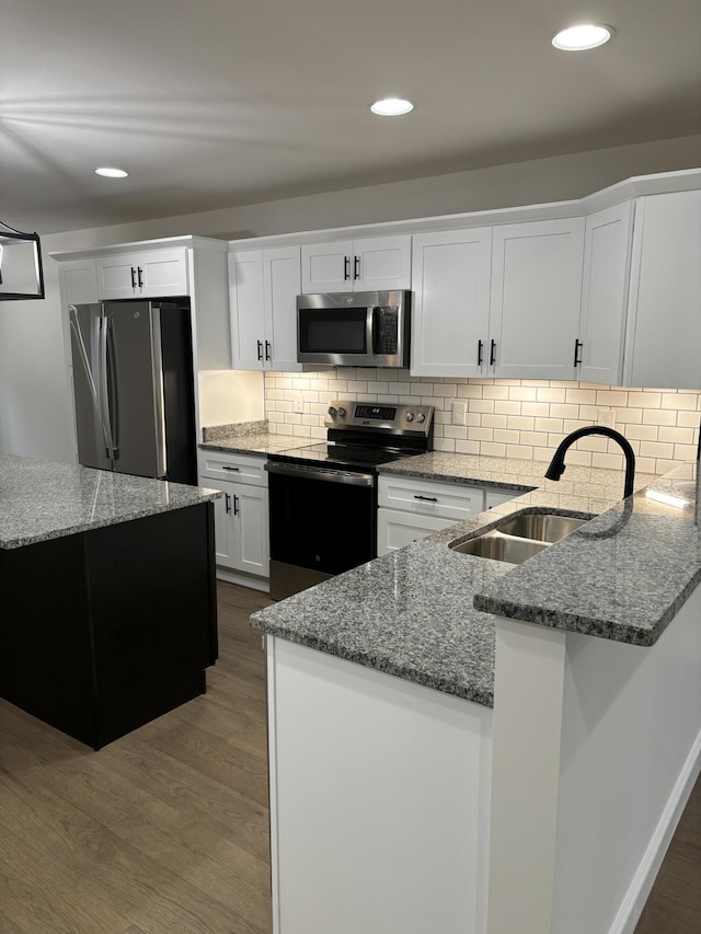 kitchen with sink, decorative backsplash, dark hardwood / wood-style flooring, white cabinetry, and stainless steel appliances