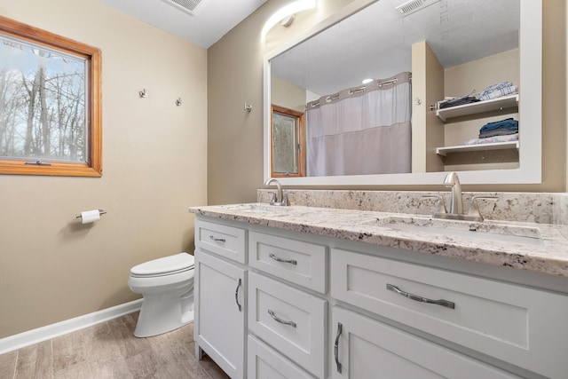 bathroom featuring hardwood / wood-style floors, vanity, toilet, and walk in shower