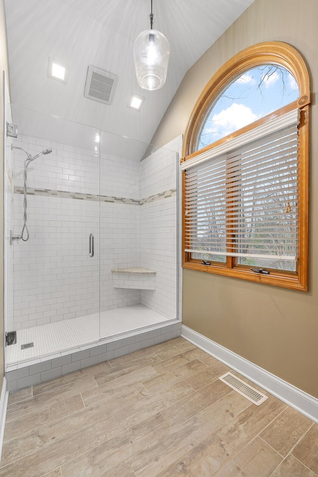 bathroom featuring vaulted ceiling and walk in shower