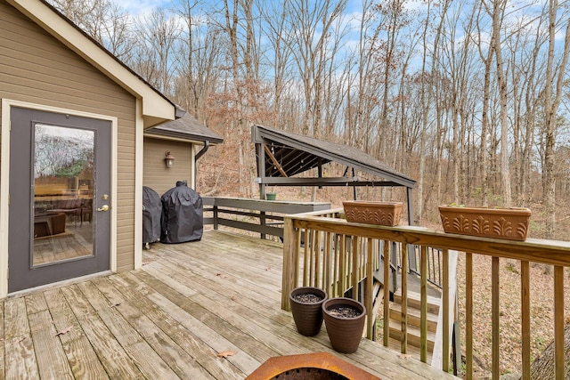 wooden terrace with a gazebo and area for grilling