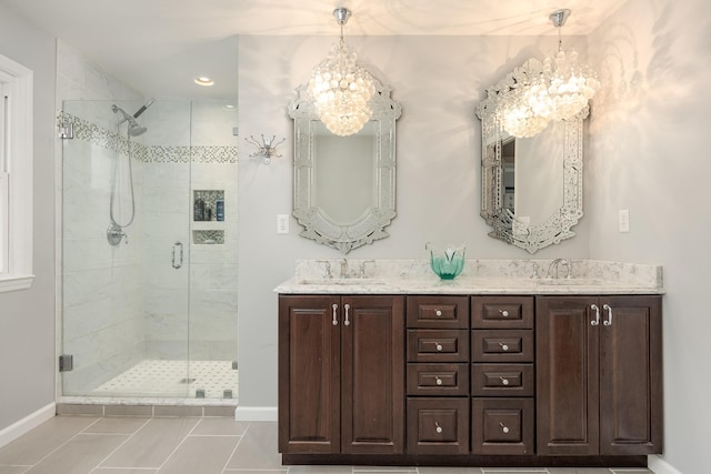 bathroom featuring tile patterned floors, vanity, walk in shower, and an inviting chandelier