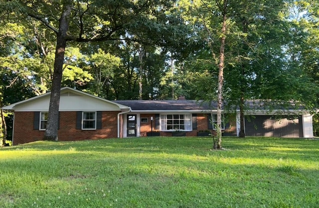 ranch-style home featuring a chimney, a front lawn, and brick siding