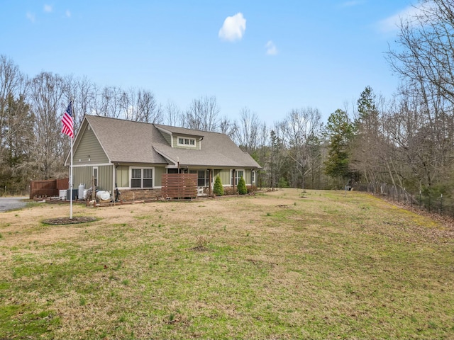 view of front of house featuring board and batten siding, a front yard, covered porch, and a shingled roof