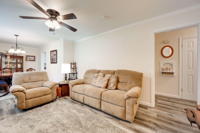 living room with hardwood / wood-style flooring, ceiling fan with notable chandelier, and ornamental molding