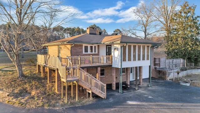 rear view of property with a wooden deck and a sunroom