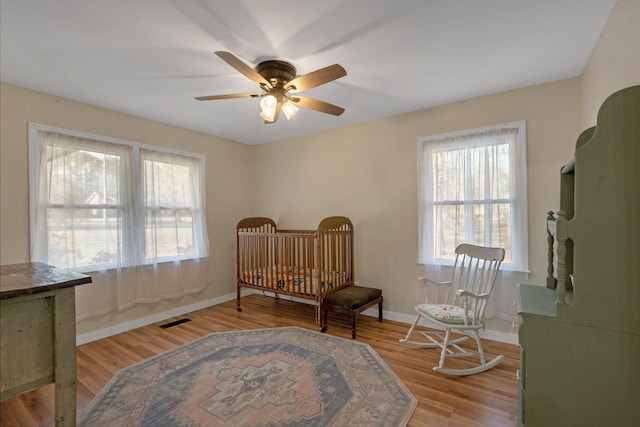 sitting room with ceiling fan and light hardwood / wood-style flooring