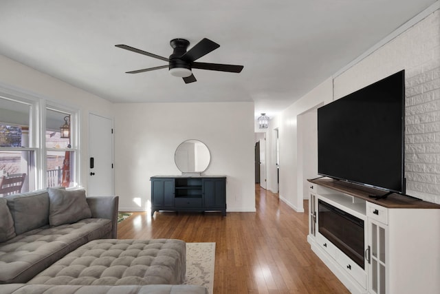 living room with ceiling fan and dark wood-type flooring