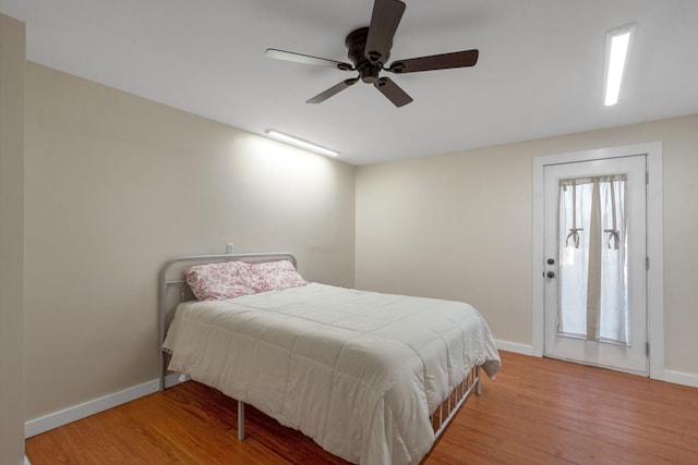 bedroom featuring ceiling fan, multiple windows, and wood-type flooring