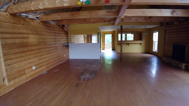 unfurnished living room with wood-type flooring and rustic walls