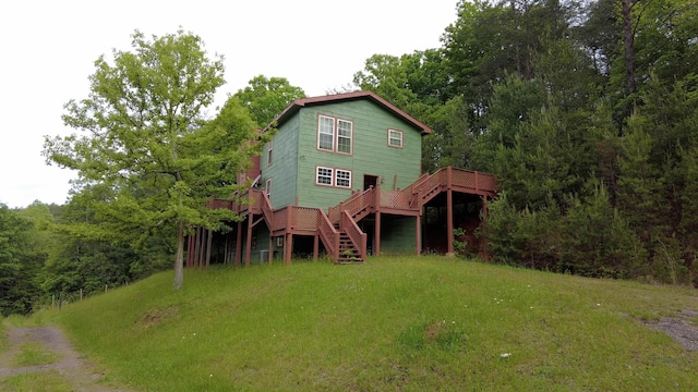 rear view of property featuring a lawn and a deck