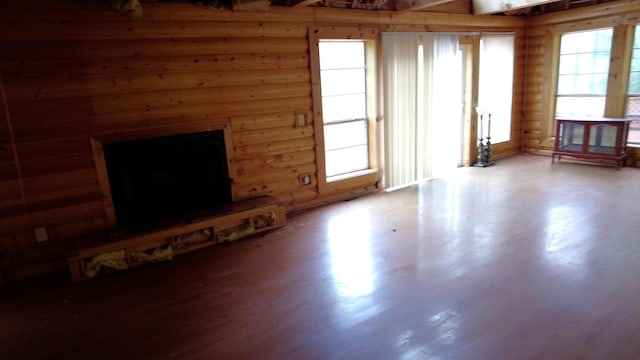 unfurnished living room with hardwood / wood-style floors and beam ceiling