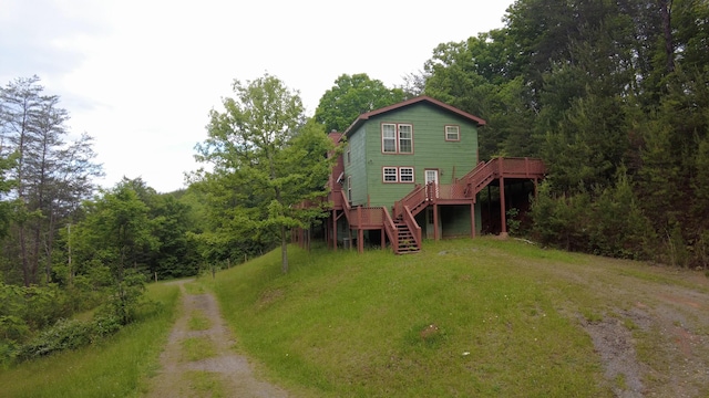 rear view of property with a lawn and a wooden deck