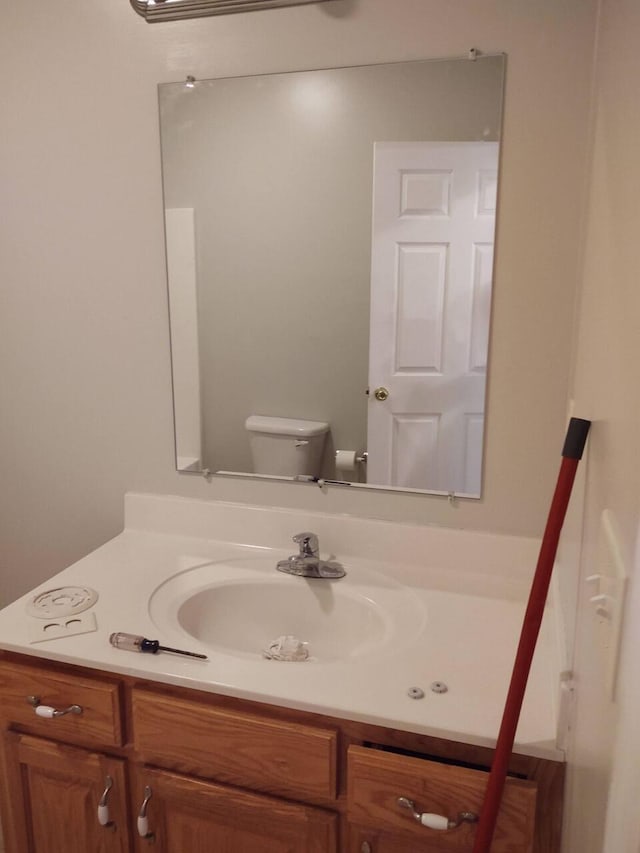 half bathroom with vanity and toilet