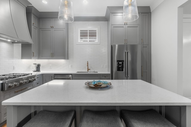 kitchen featuring gray cabinetry, decorative light fixtures, premium range hood, and stainless steel appliances