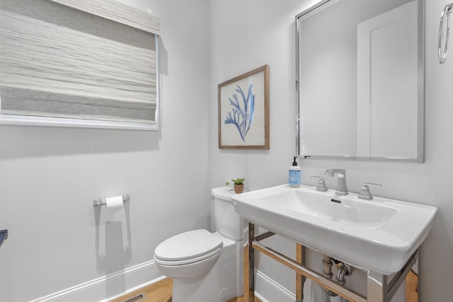 bathroom with hardwood / wood-style floors and toilet