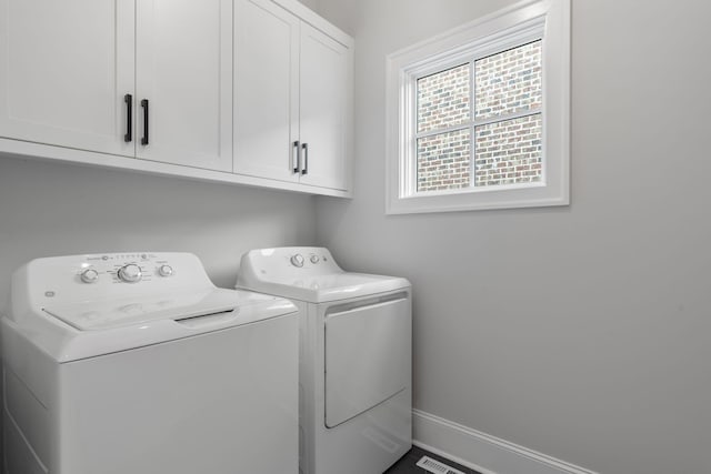 laundry area featuring separate washer and dryer and cabinets