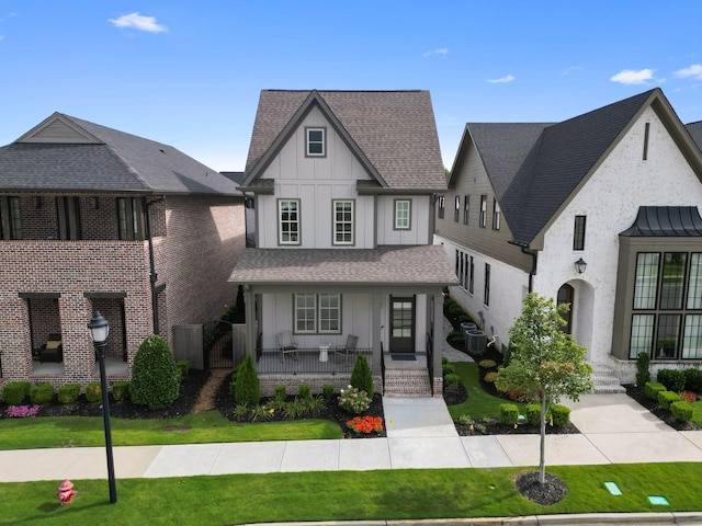 view of front of property with cooling unit, covered porch, and a front lawn