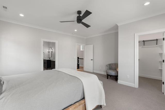 carpeted bedroom with ensuite bathroom, ceiling fan, crown molding, a spacious closet, and a closet