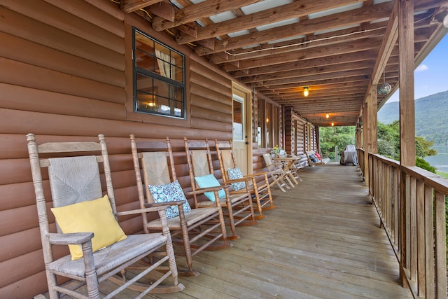 deck featuring a mountain view and covered porch